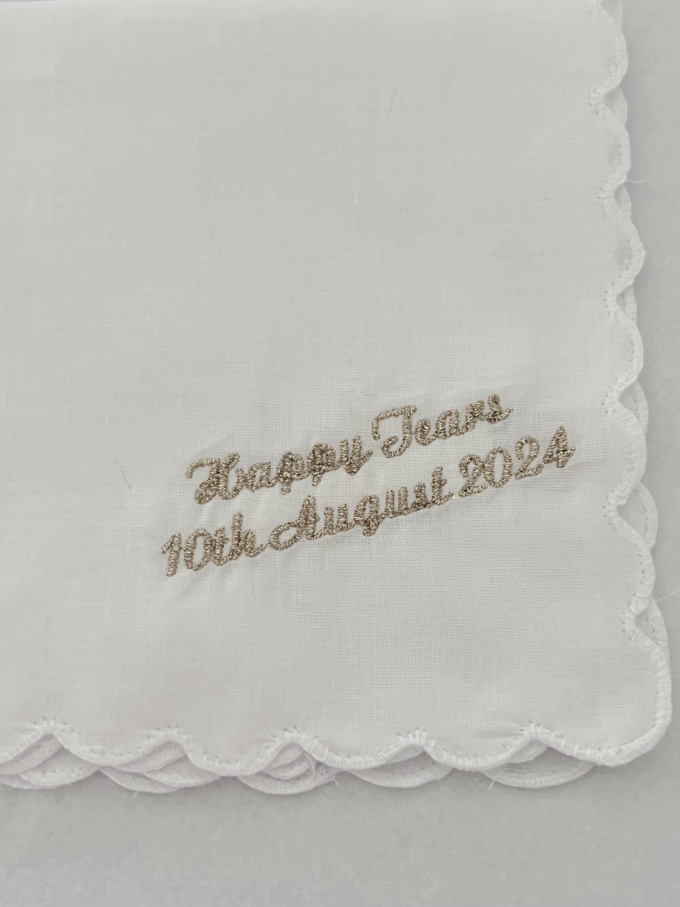 Embroidered handkerchief with 'Happy Tears 10th August 2024' text on a white background