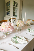 Elegant table setting with floral arrangements and candles in a dining room.
