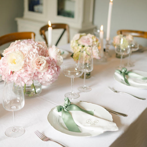 Elegant table setting with floral arrangements and candles in a dining room.