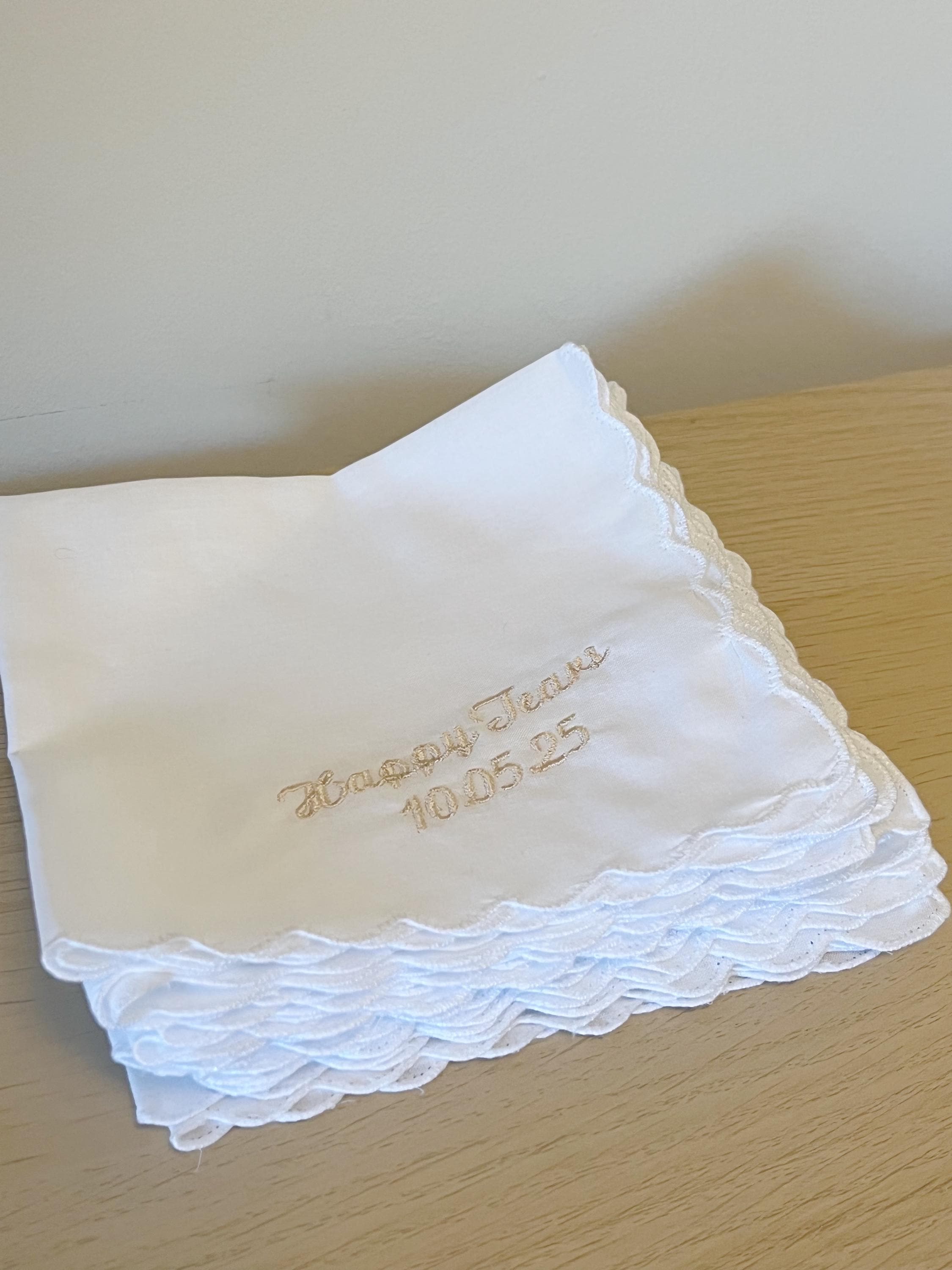 White handkerchief with embroidered text on a wooden surface
