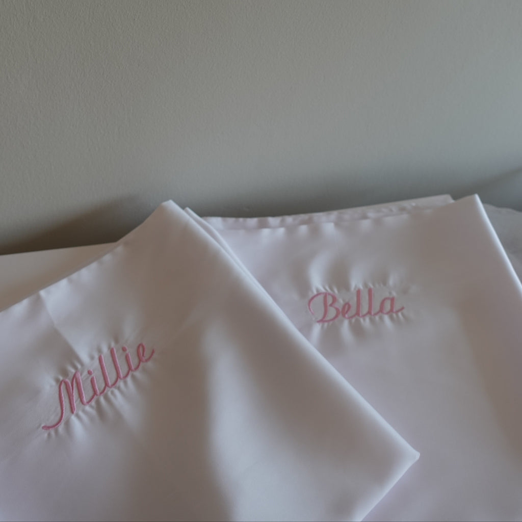 satin white pillowcases with embroidered names in pink thread