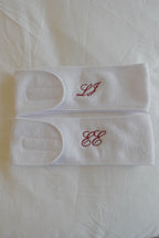 two white spa headbands with embroidered monograms