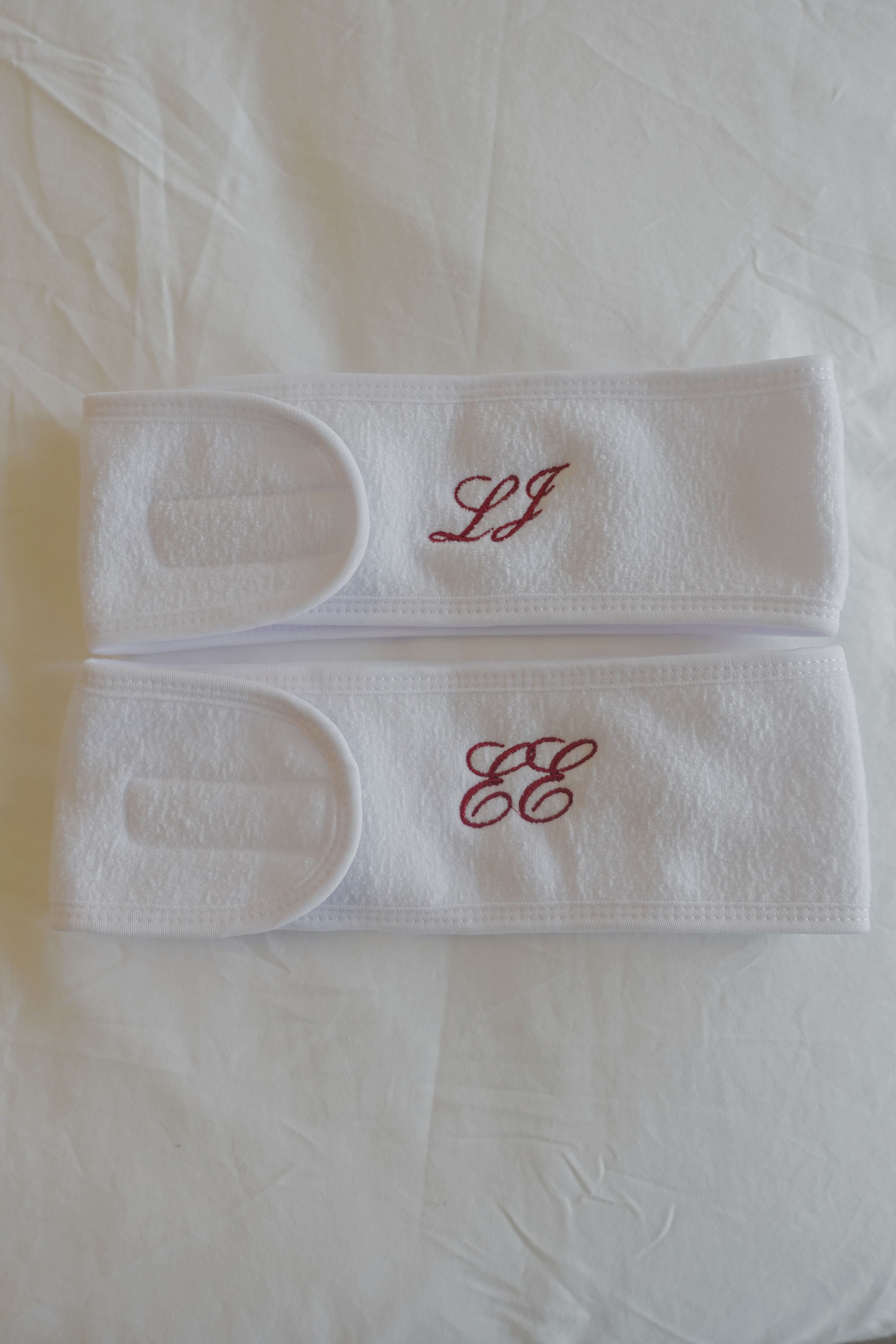 two white spa headbands with embroidered monograms