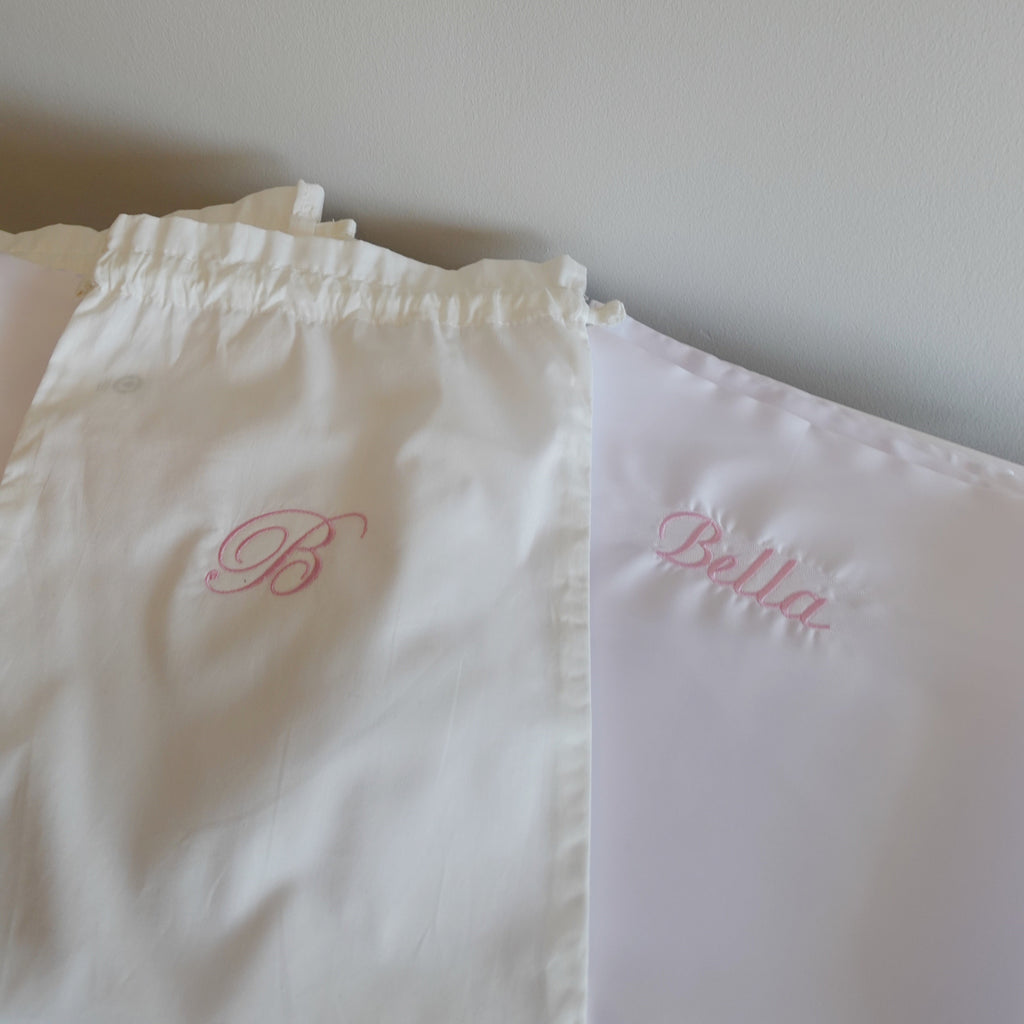 one white pillow with 'Bella' embroidered on them against a plain background.